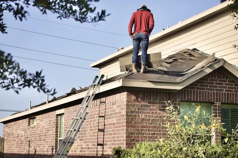 Professional roofer working on a residential roof in Willow